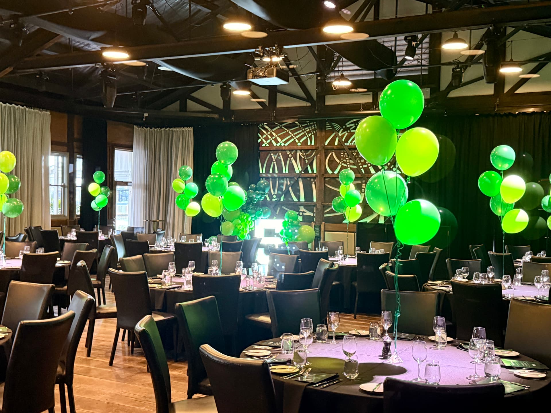 Restaurant interior with vibrant green ceiling balloon clusters
