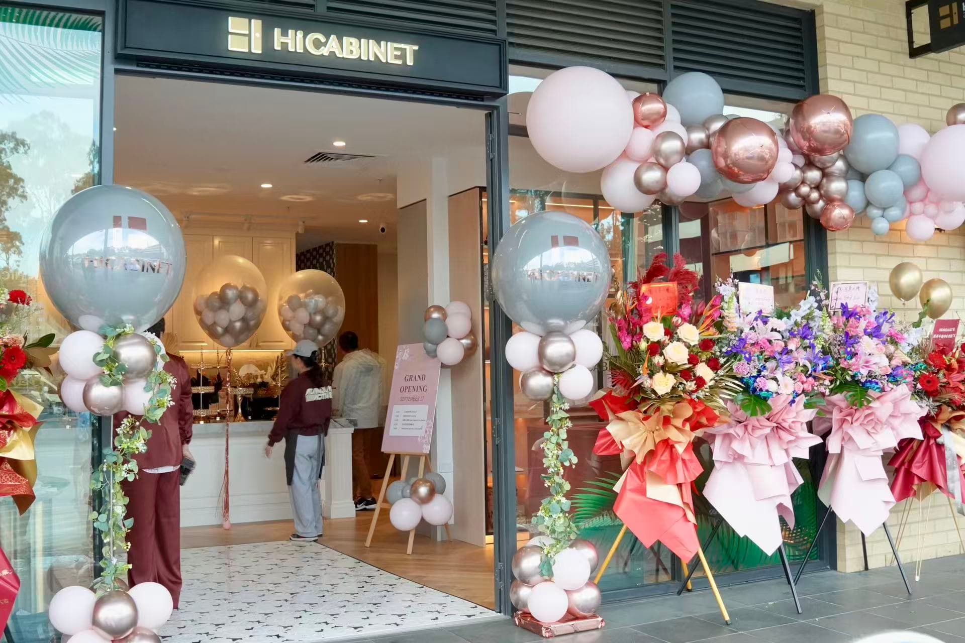 HICABINET storefront entrance with silver, white, pink, purple and gold balloons and floral arrangements