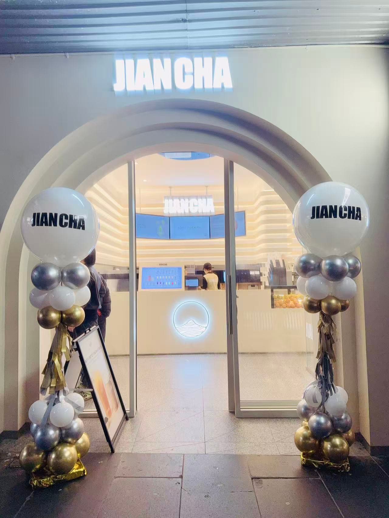 JIAN CHA store arched entrance with silver, white and black balloon columns