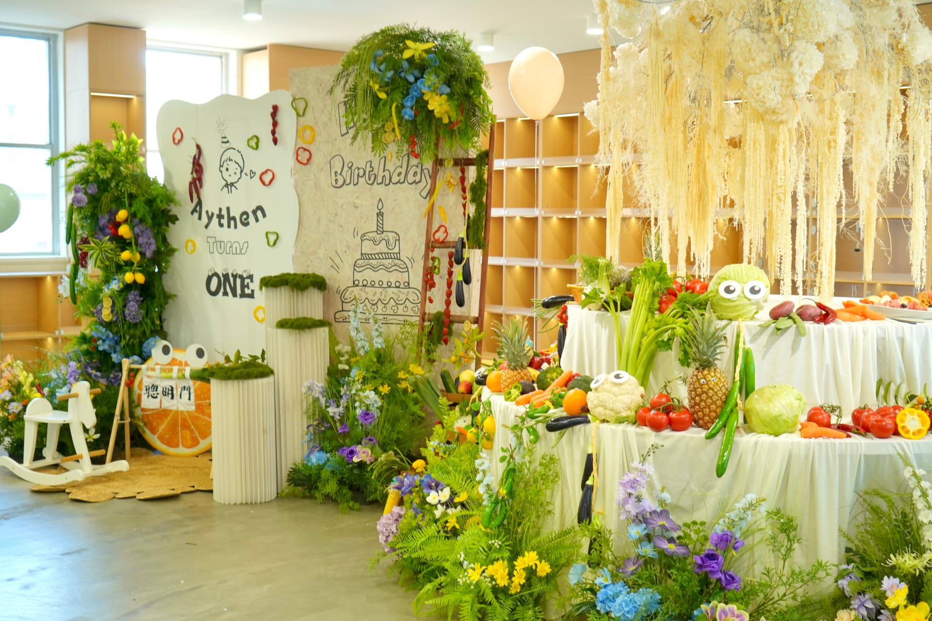 Garden themed 1st birthday with colourful fruit dessert table, greenery and white hanging florals