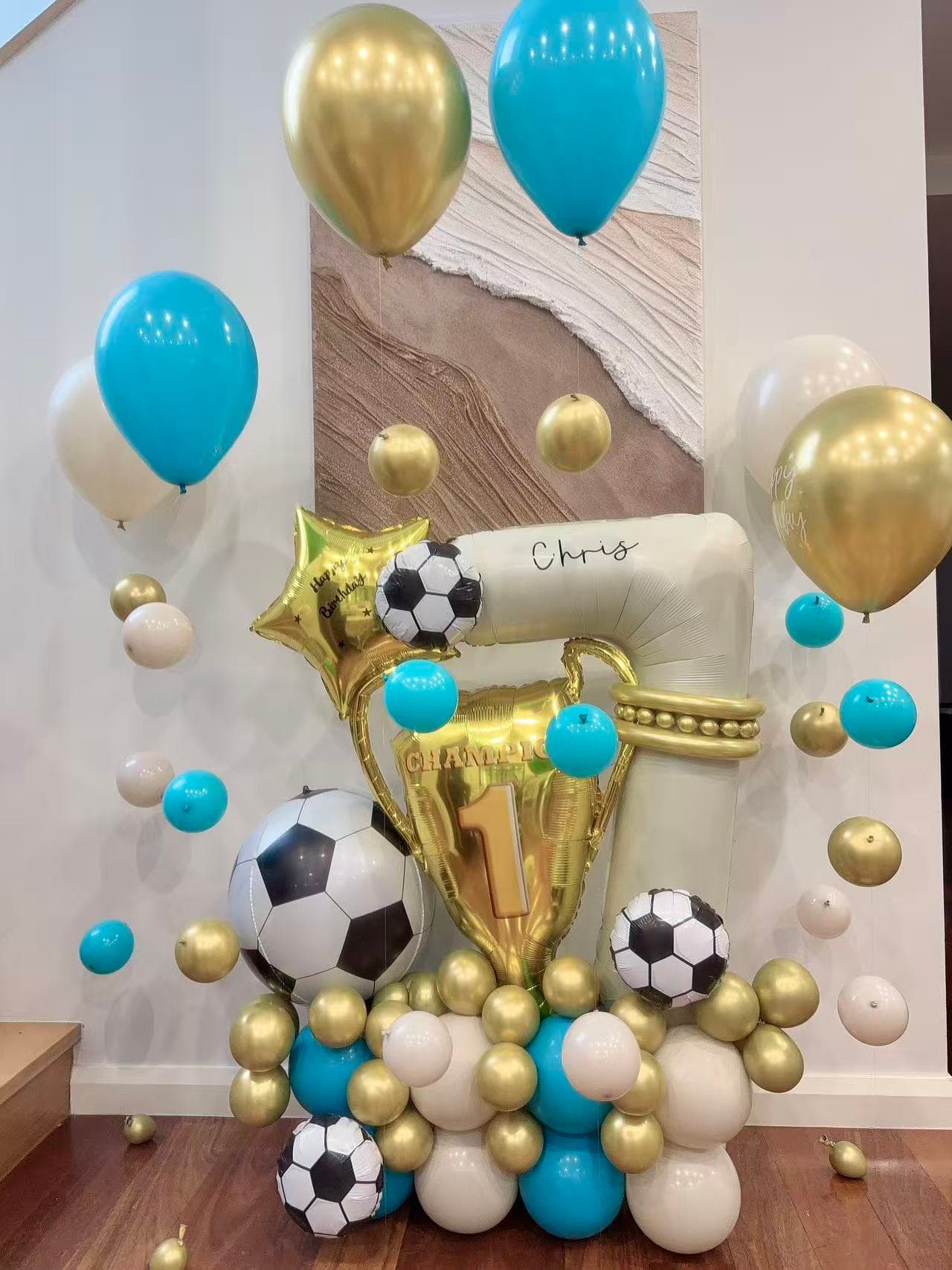 Soccer and football themed 1st birthday with teal, gold, white and black balloons and Chomp sign