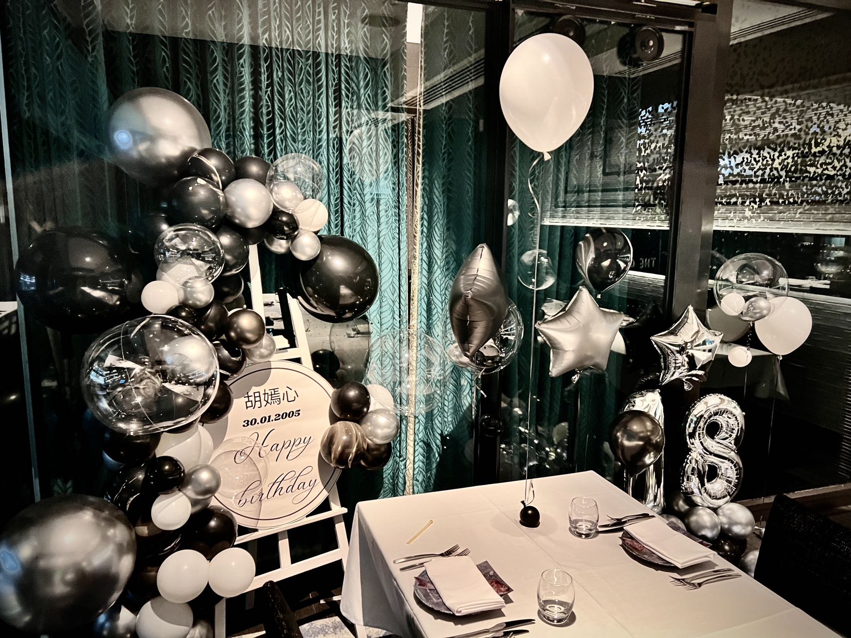 Elegant 18th birthday setup with silver and black balloons and star decorations