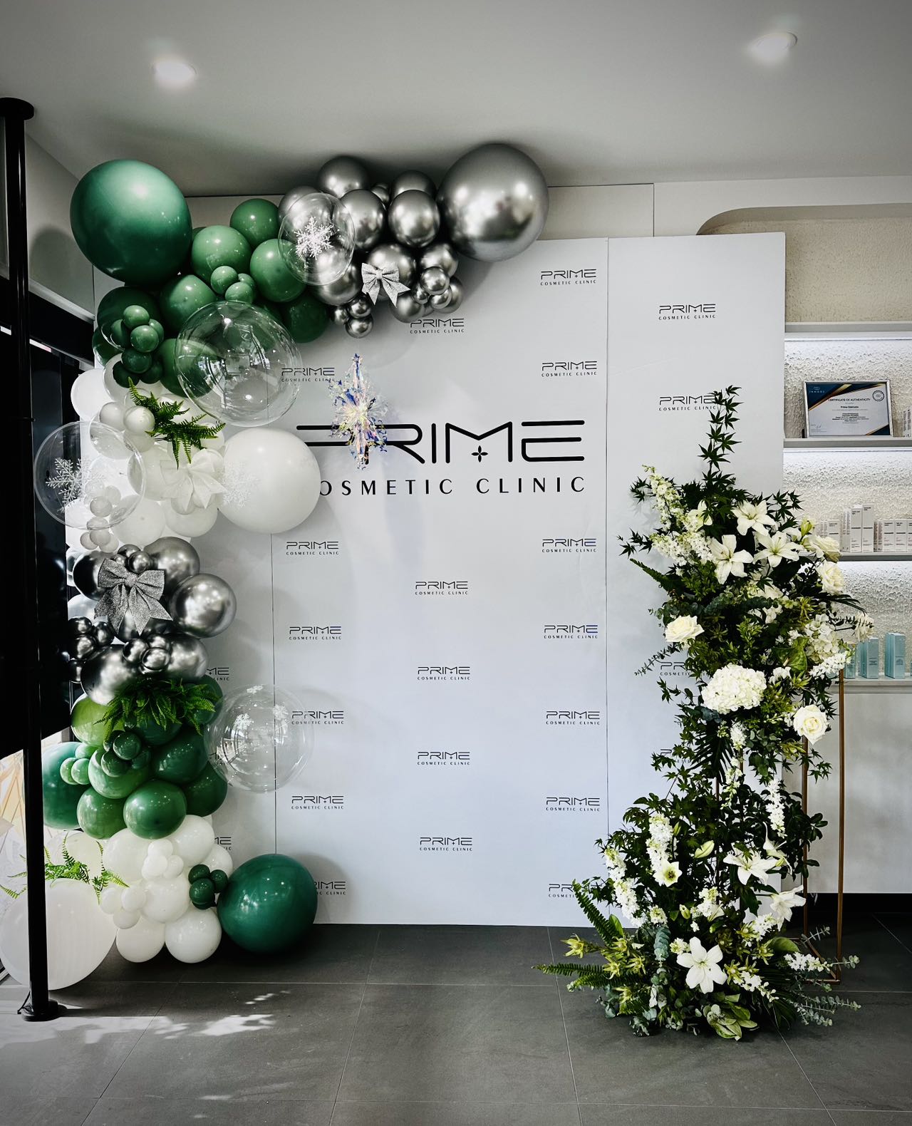 Elegant cosmetic clinic launch with green and silver balloons and floral arrangements