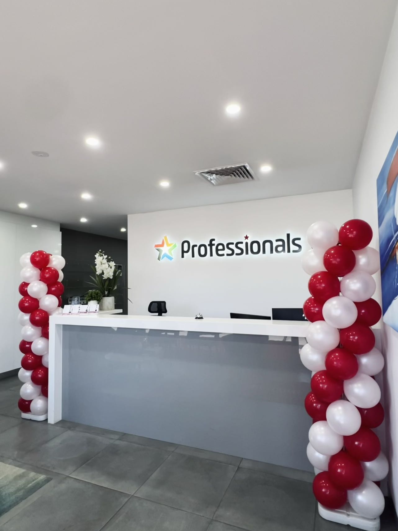 Professional office opening with red and white spiral balloon columns