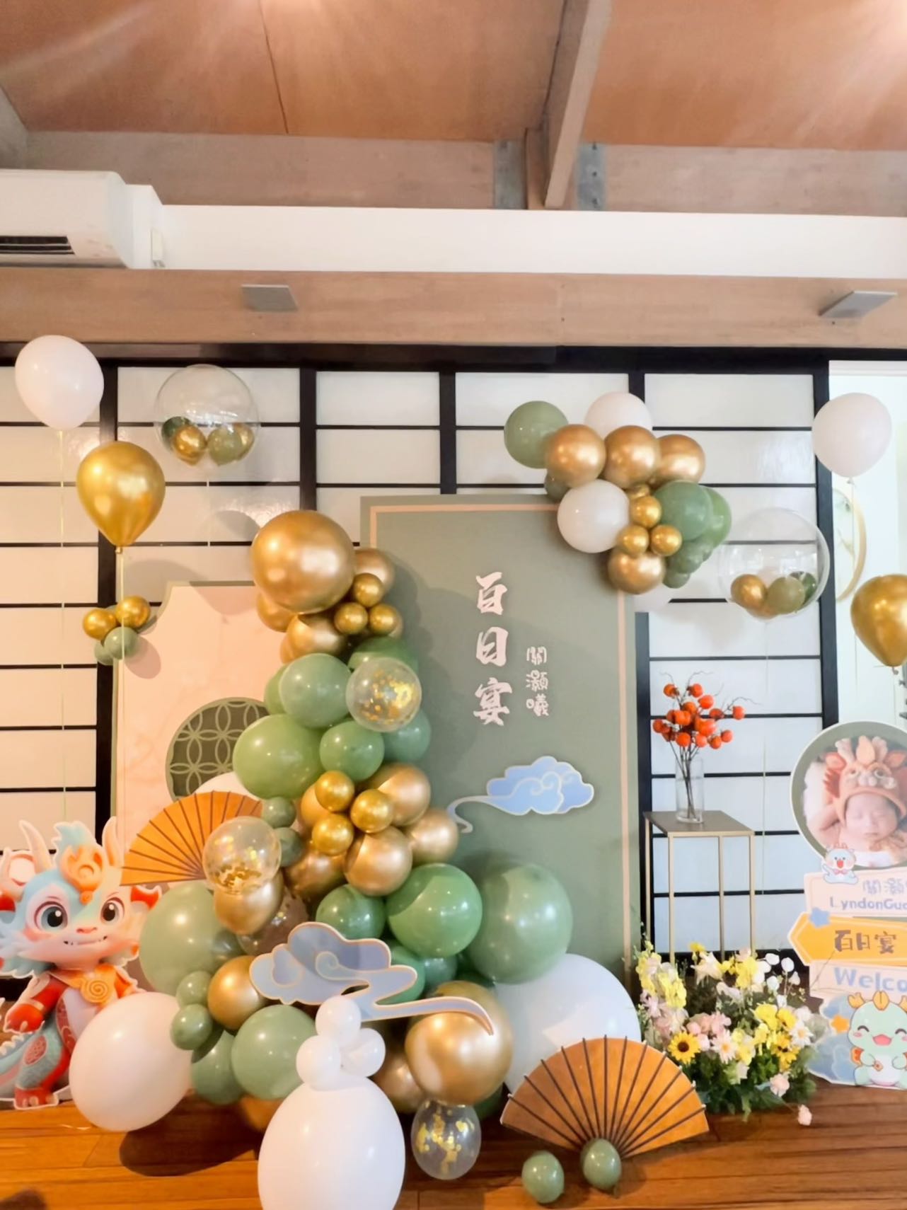 Modern Chinese 100 days celebration with sage green and gold balloon decorations