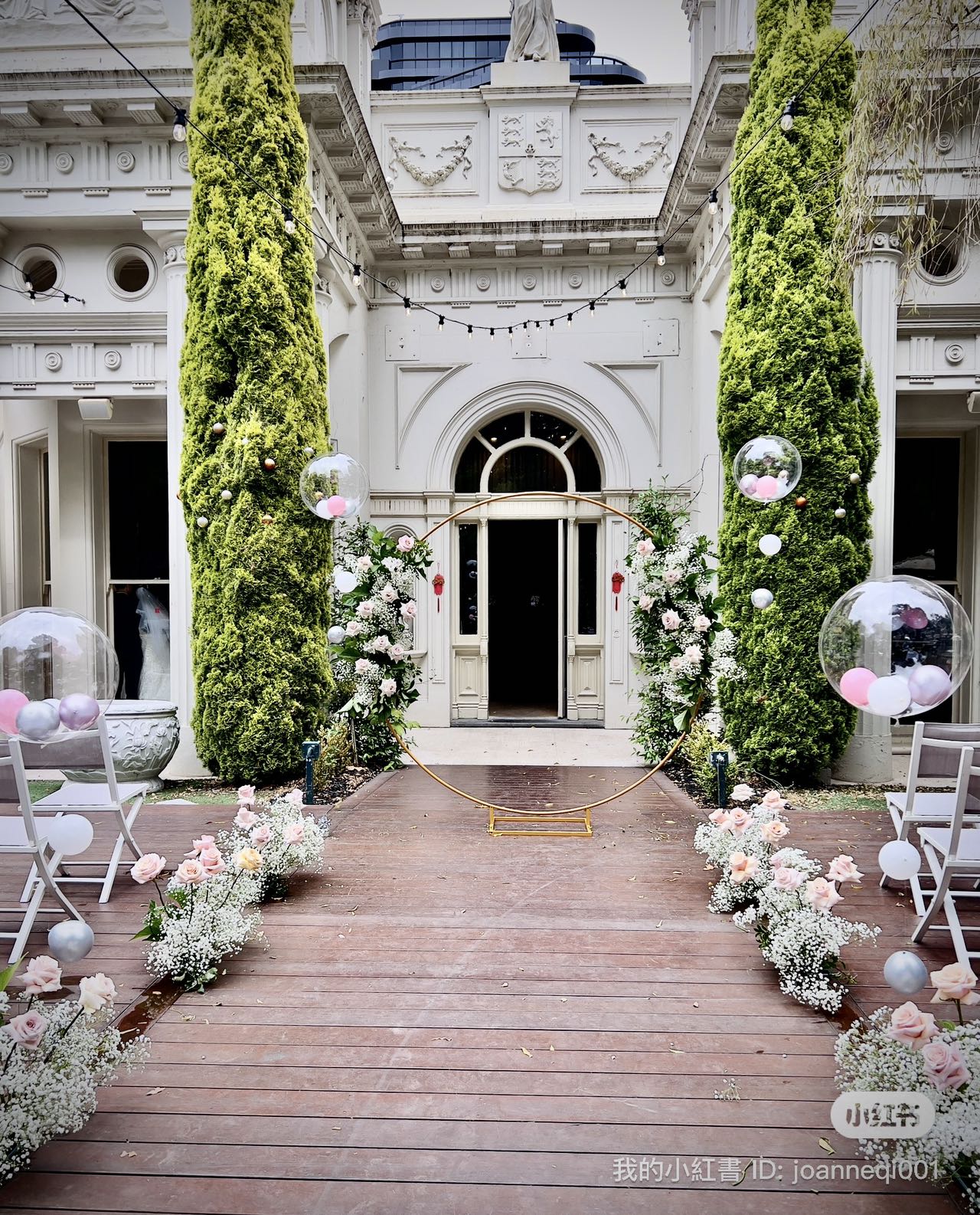 Romantic garden wedding ceremony with pink floral arrangements and bubble balloons