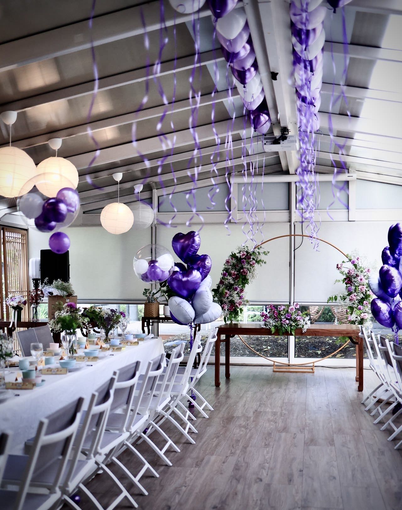 Romantic wedding decoration with purple and silver balloons and floral arrangements