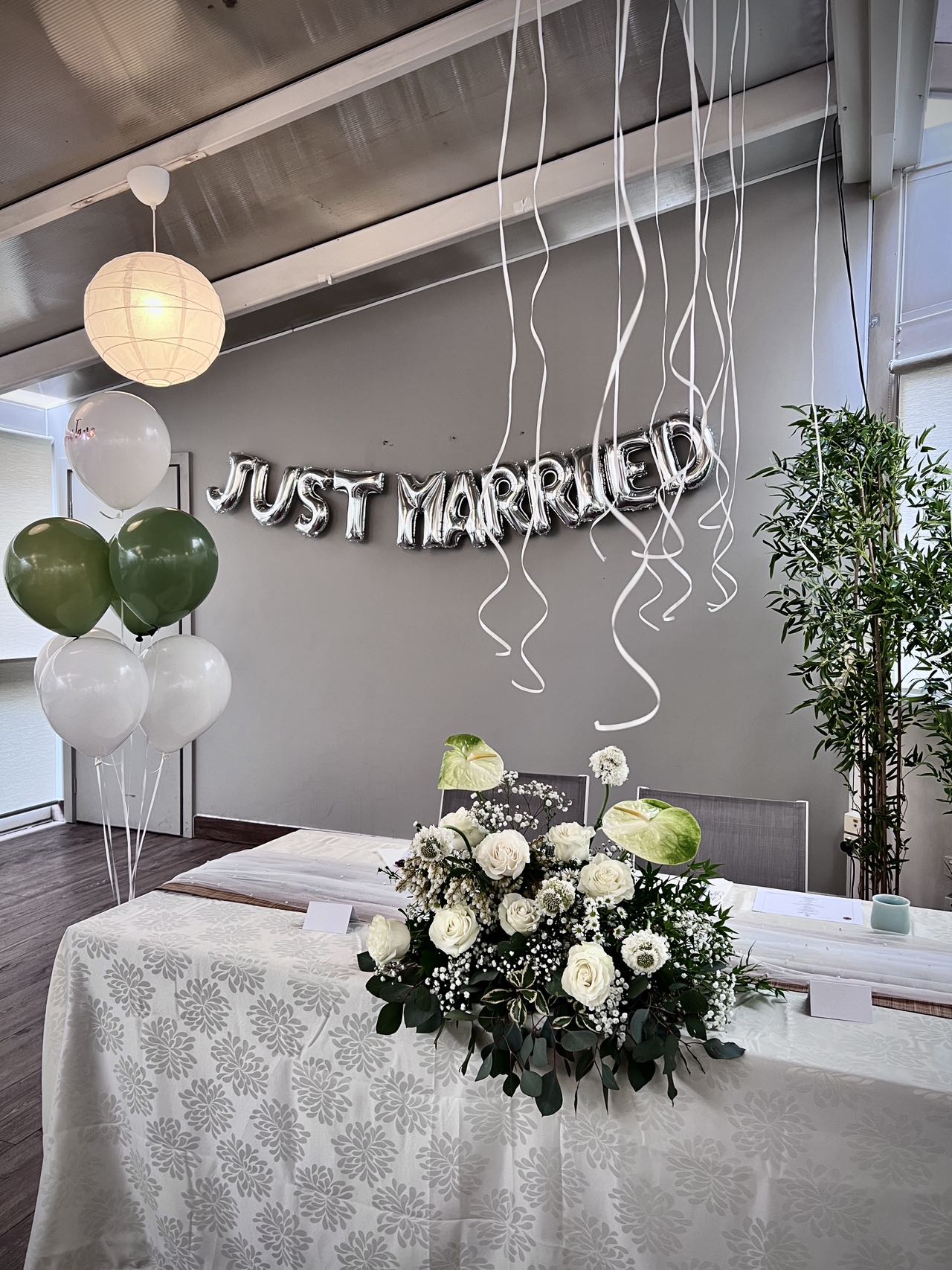 Simple and elegant wedding setup with white roses and green balloons